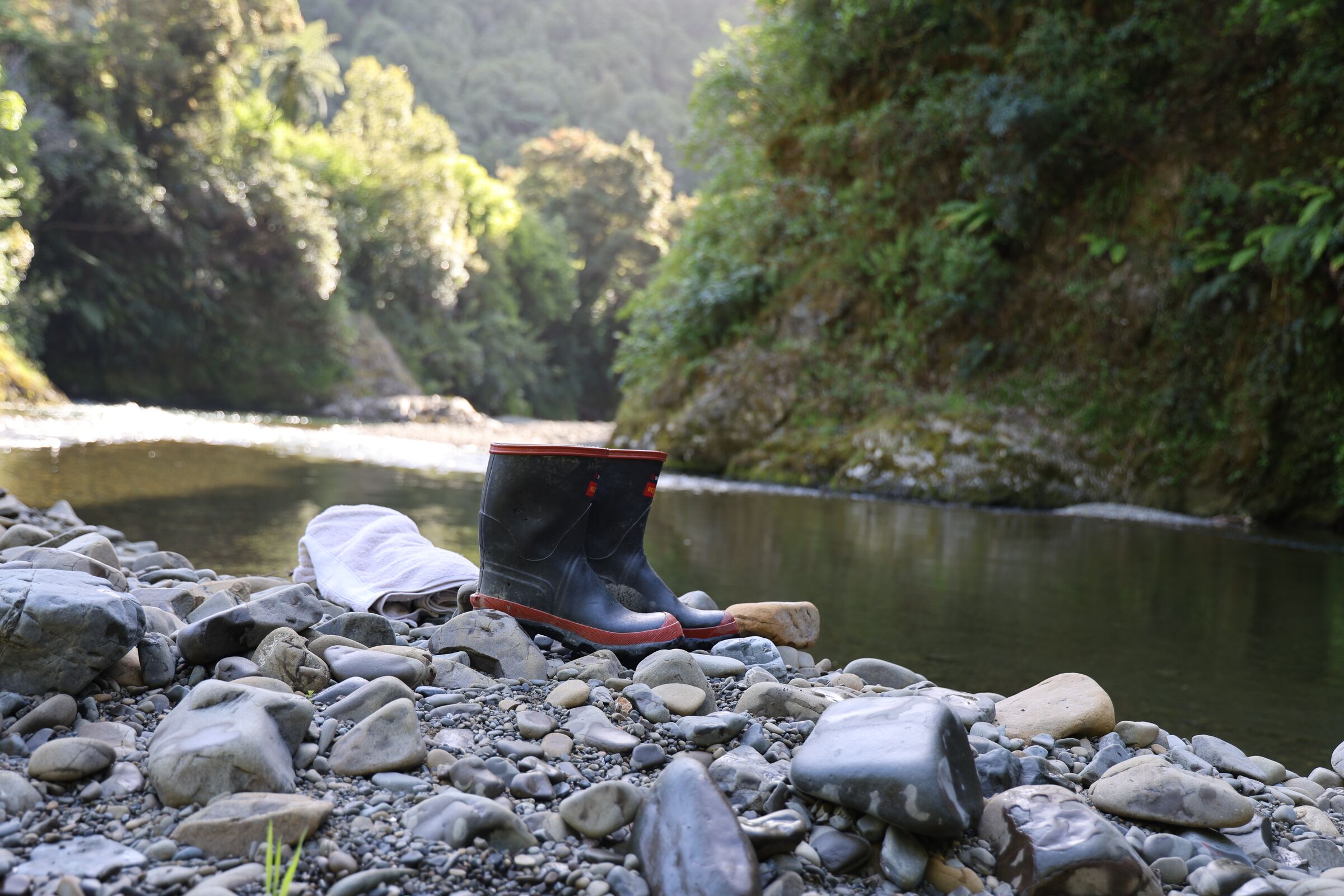 Boots on the river stones at Te Pākau, Waimana